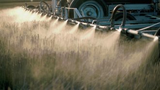 A machine sprays pesticides over a field.